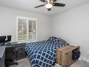 Bedroom featuring a ceiling fan and carpet