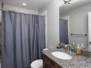 Main floor Bathroom with toilet, vanity, and a shower with curtain