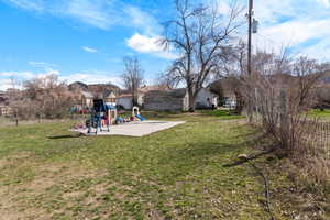 View of yard with a patio, a fenced backyard, and a playground