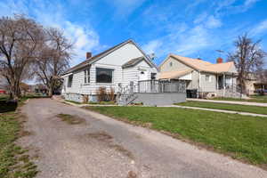 View of front of house with a front yard, gravel driveway, and a chimney