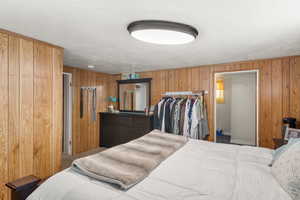 Bedroom featuring wooden walls