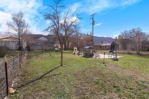 View of yard featuring fence and a playground
