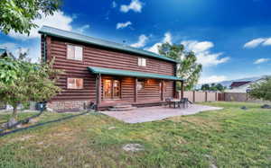 Rear view of property with a patio, metal roof, log exterior, and fence