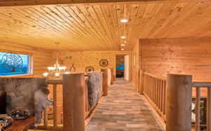 Hall with an inviting chandelier, rustic walls, recessed lighting, wood ceiling, and wood pattern tile flooring