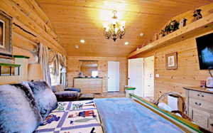 Bedroom with wood ceiling, a chandelier, and lofted ceiling