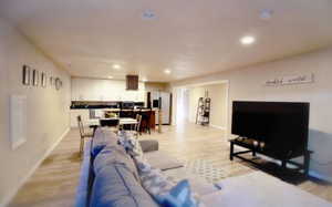 Living room with baseboards, recessed lighting, and light wood-style floors