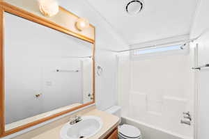 Full bathroom featuring  shower combination, vanity, and toilet