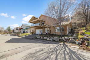 View of front facade with an attached garage, stucco siding, a balcony, and aphalt driveway