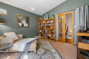 Living area featuring vaulted ceiling and carpet floors