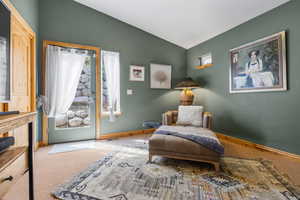 Living area with visible vents, baseboards, lofted ceiling, and carpet floors