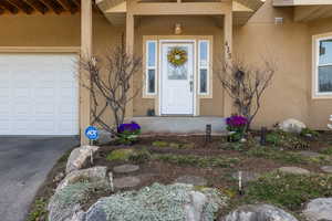 Doorway to property featuring a garage and stucco siding