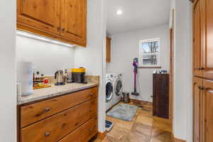 Laundry room with washing machine and clothes dryer and cabinet space