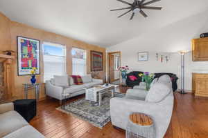 Living area with hardwood / wood-style floors, a ceiling fan, and vaulted ceiling