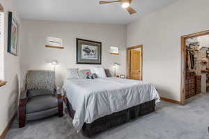 Bedroom with baseboards, a ceiling fan, carpet, and vaulted ceiling