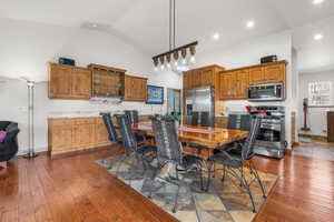 Dining area with high vaulted ceiling, baseboards, dark wood finished floors, and recessed lighting