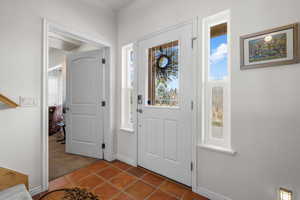 Foyer entrance with tile patterned floors and baseboards