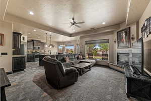 Living room featuring visible vents, a premium fireplace, baseboards, and ceiling fan
