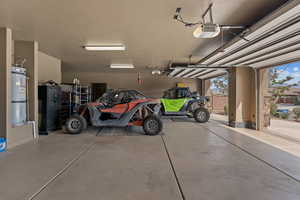 Garage featuring water heater and a garage door opener