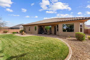 Back of house with a patio area, a yard, fence, and an outdoor fire pit