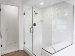 Bathroom with a stall shower and recessed lighting