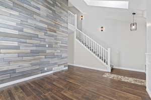 Interior space with visible vents, baseboards, wood finished floors, and a skylight