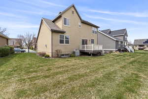 Back of property featuring a deck, a yard, and central AC unit