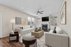 Living room featuring ceiling fan, a fireplace, light wood-style flooring, recessed lighting, and baseboards