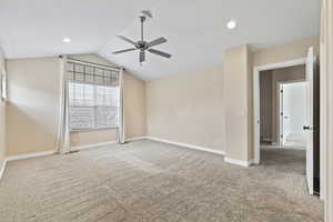 Carpeted empty room featuring baseboards, a ceiling fan, lofted ceiling, and recessed lighting