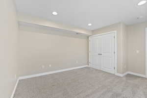 Unfurnished bedroom with carpet flooring, baseboards, and recessed lighting