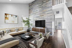 Living room featuring a towering ceiling, baseboards, recessed lighting, stairway, and dark wood finished floors