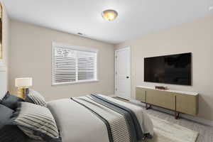 Carpeted bedroom featuring baseboards and visible vents