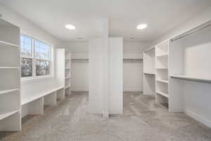 Walk in closet featuring visible vents and carpet flooring