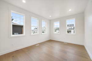 Unfurnished room featuring visible vents, baseboards, recessed lighting, and wood finished floors