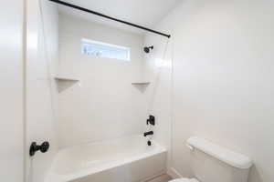 Full bathroom featuring washtub / shower combination and toilet