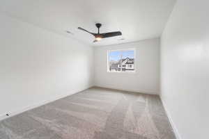 Spare room with visible vents, ceiling fan, light colored carpet, and baseboards
