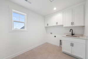 Laundry room featuring baseboards, washer hookup, a sink, cabinet space, and electric dryer hookup