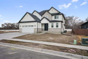 Craftsman-style home featuring a standing seam roof, metal roof, fence, and concrete driveway