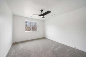 Carpeted empty room featuring visible vents, baseboards, and ceiling fan