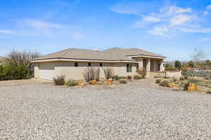 View of front facade featuring concrete driveway, a tile roof, a garage, and stucco siding