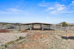 View of yard featuring an exterior structure, a rural view, a mountain view, and an outbuilding