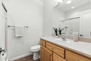 Full bath featuring vanity, baseboards, recessed lighting, toilet, and a shower stall