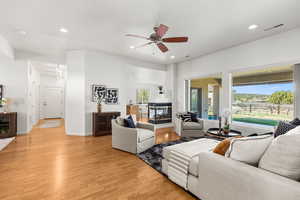 Living room featuring recessed lighting, visible vents, light wood-type flooring, and a ceiling fan