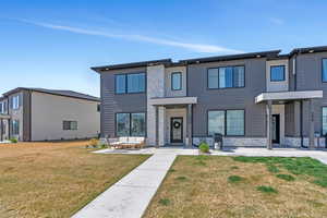 View of front of home with a front yard and stone siding