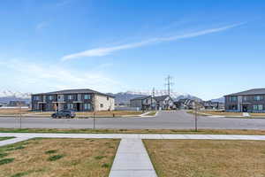 View of road with sidewalks, curbs, a mountain view, and a residential view