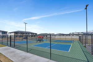View of tennis court featuring a residential view and fence
