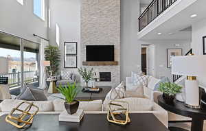 Living room with stairs, a towering ceiling, and a fireplace