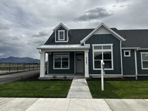 View of front of house with board and batten siding, covered porch, and a mountain view