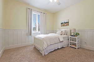 Main Floor bedroom with ceiling fan and wainscoting
