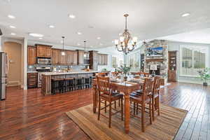 Dining area featuring  wood flooring, a stone fireplace, recessed lighting, and lofted ceiling