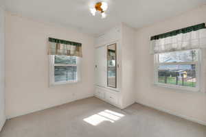 Carpeted spare room with baseboards